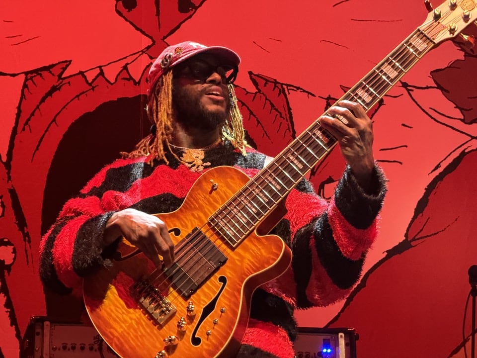 Close-up of Thundercat playing the bass guitar