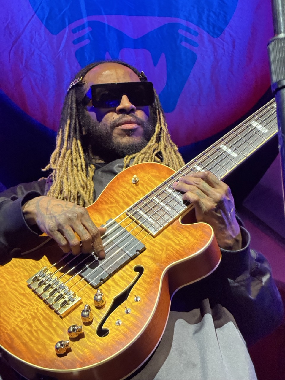 Close-up of Thundercat playing a 6-string bass guitar