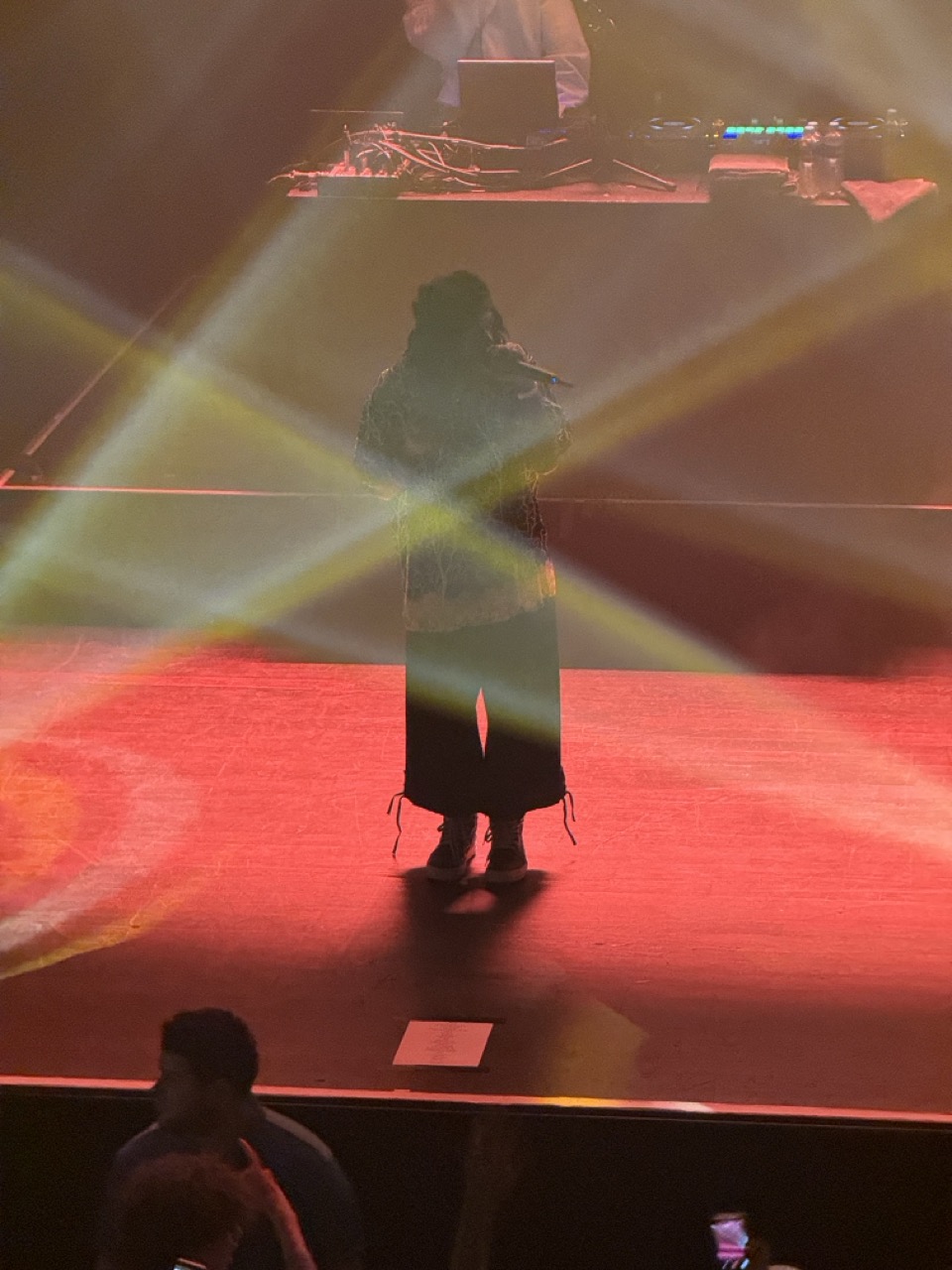 A silhouette of JID live on stage.