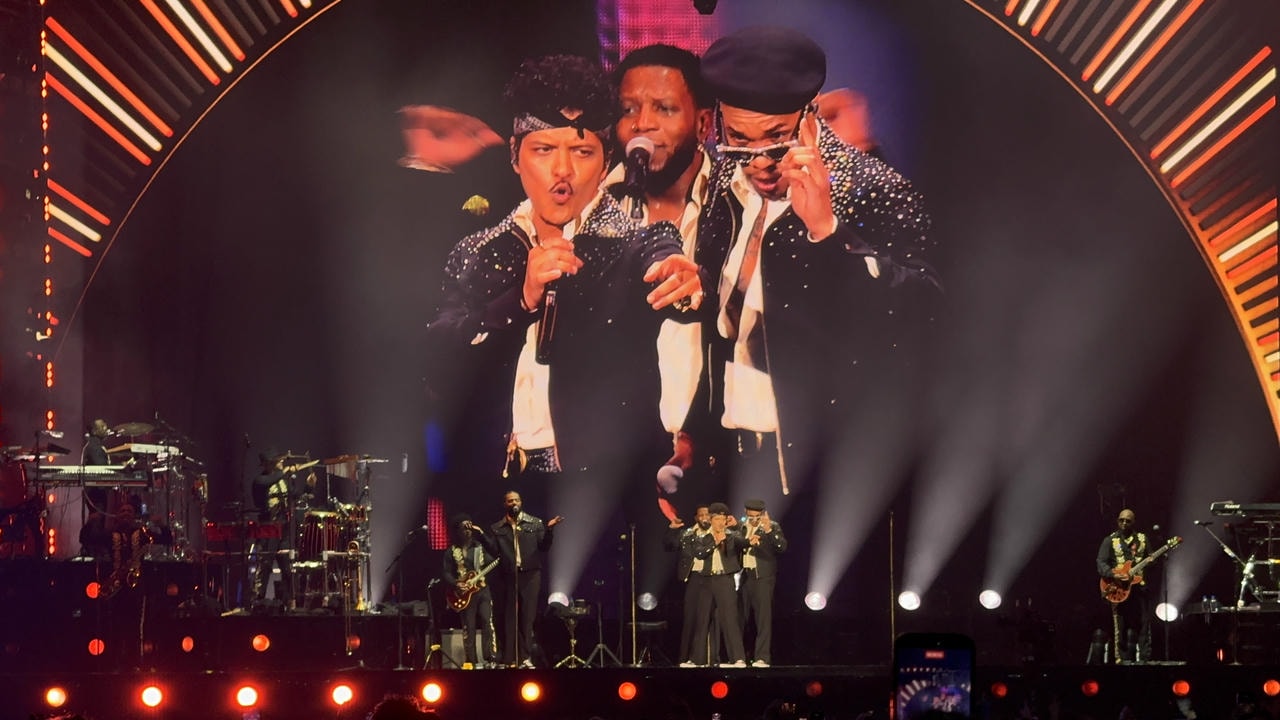 Bruno Mars and Anderson .Paak on stage, pointing into the crowd.