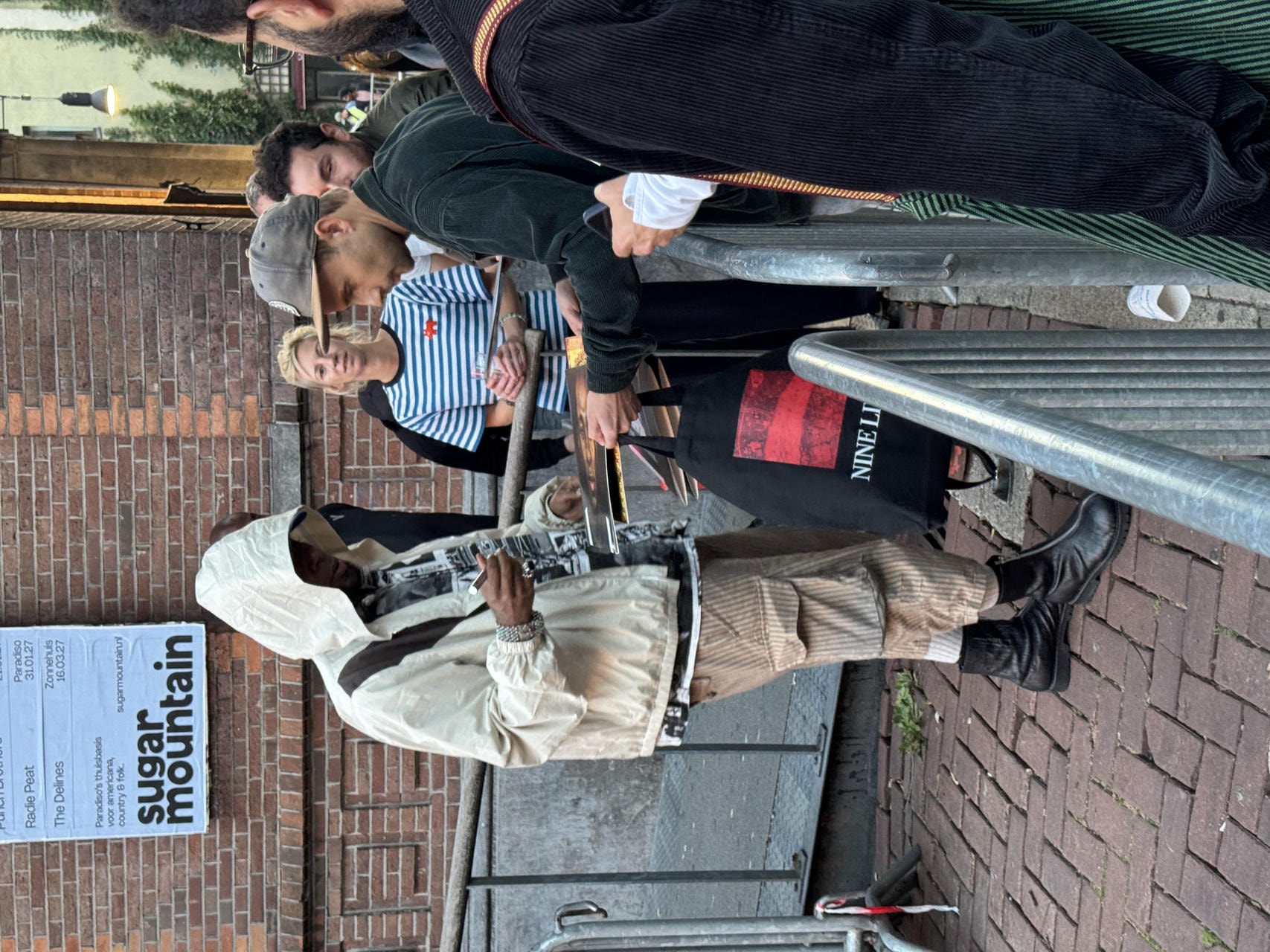 Yasiin Bey aka Mos Def signing someone's vinyl record outside Paradiso