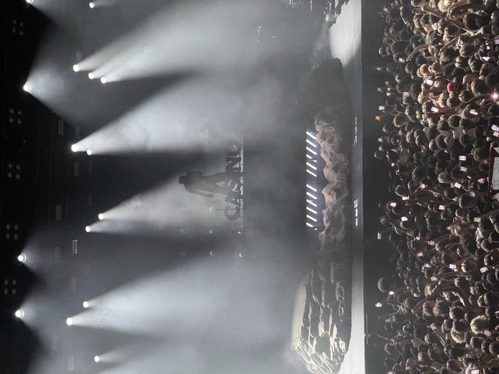 Baby Keem performing live on stage. The foreground shows a big crowd of people looking up at him.